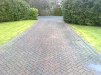 a stained dirty block paved drive before cleaning